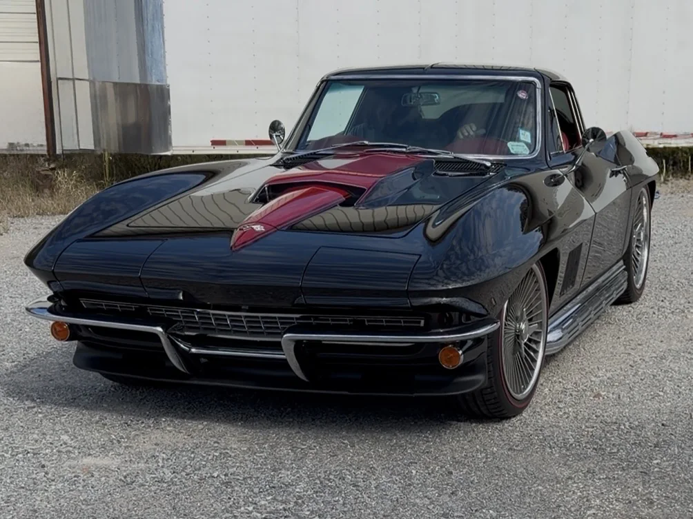 Finished gloss black classic Corvette coupe front three-quarter view with stinger hood.