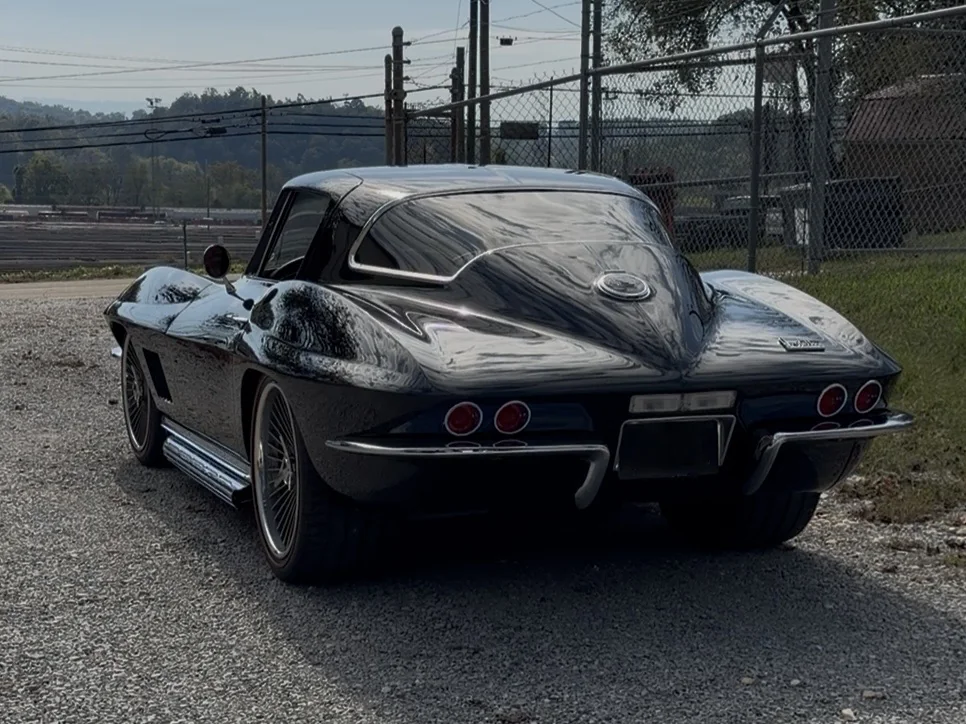 Finished gloss black classic Corvette coupe rear fastback and taillight view.