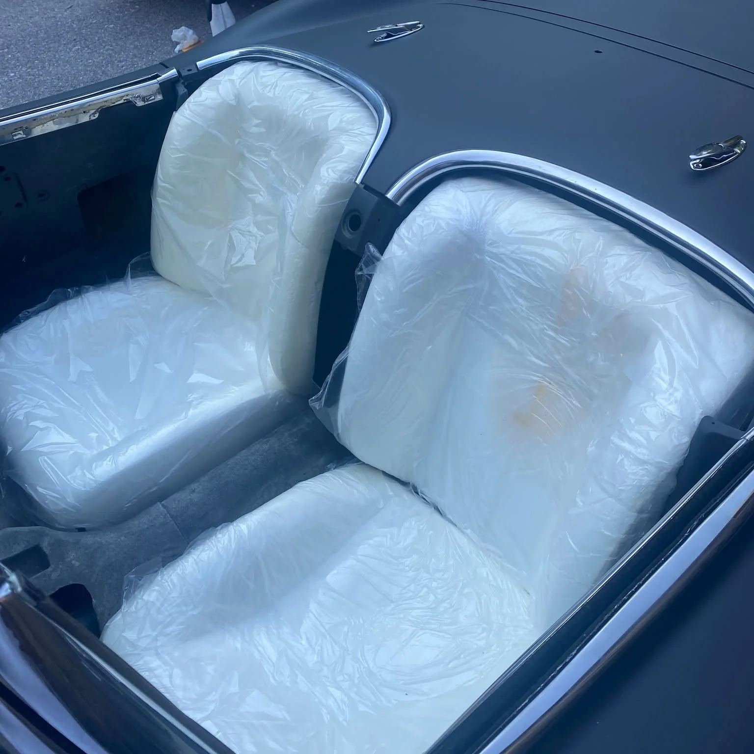 Molded Corvette seat pods test-fitted inside vehicle cockpit with chrome waterfall.