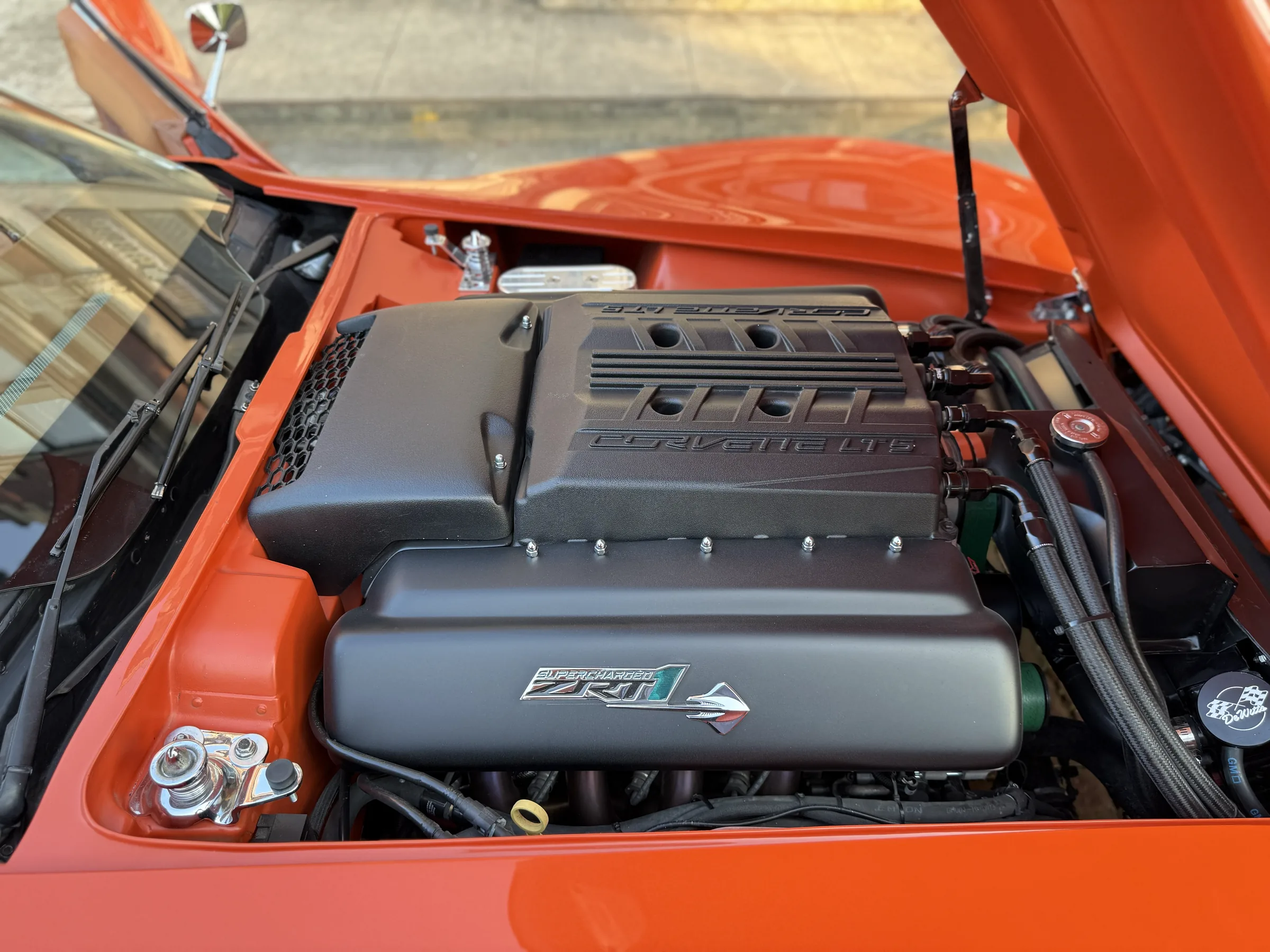 Engine bay detail of the orange classic Corvette.
